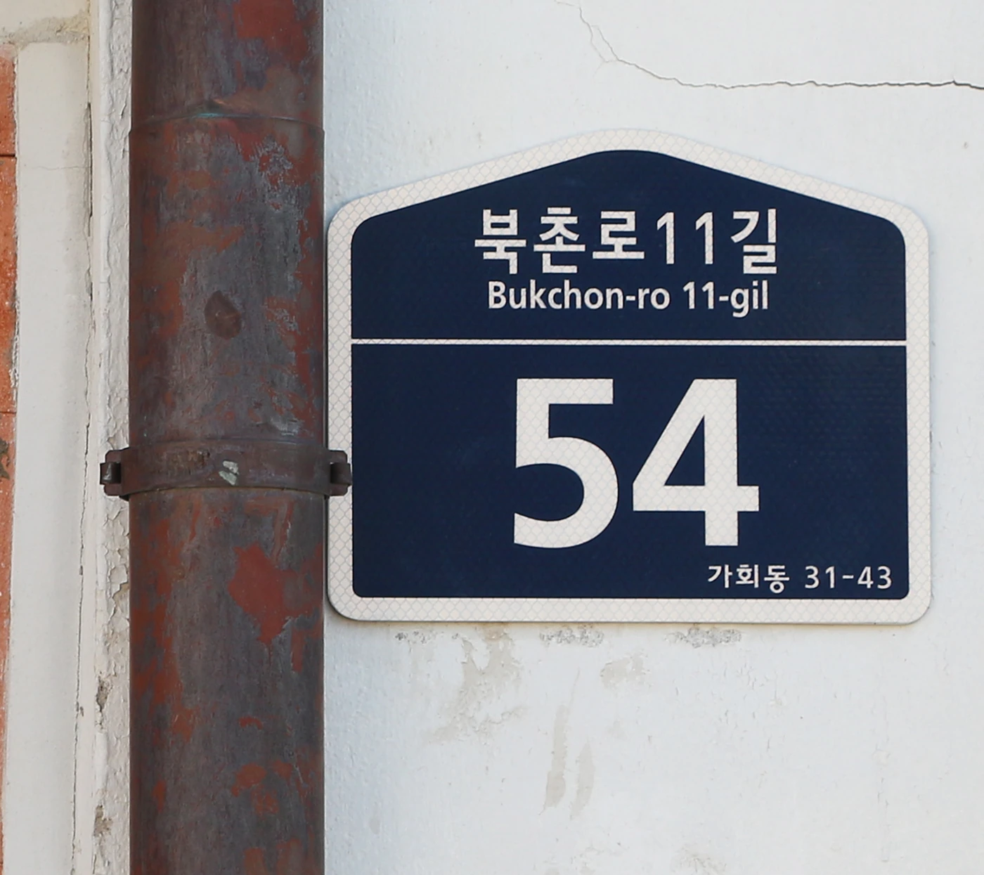 Korean Bukchon-ro 11-gil road-name plate with Roman letters and building number 54